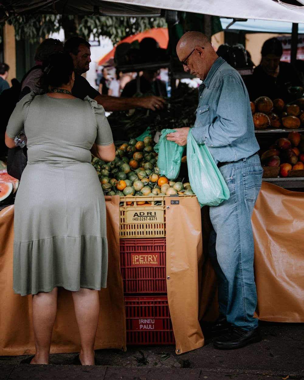 Feira do bairro: pessoas comprando frutas e verduras nas barracas do comércio local